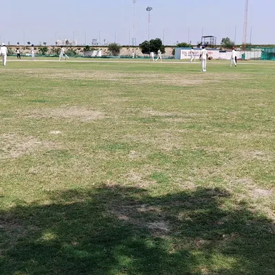 A view of our main cricket ground during a weekly practice match. We have a lush, well-maintained grass field to ensure you get experience in real match conditions, which is a core part of our residential program.