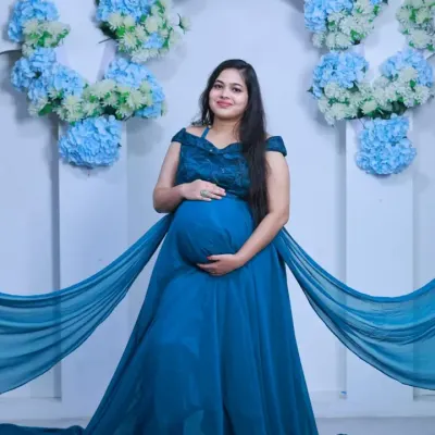 A classic maternity portrait in my studio. The flowing blue gown and floral backdrop create a serene and beautiful setting to celebrate your pregnancy.