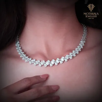 A breathtaking diamond necklace designed with an intricate, leaf-like pattern. This piece sits beautifully on the collarbone, offering a statement of pure, classic elegance.