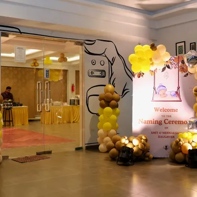 We set a welcoming tone for this naming ceremony with a custom entrance display. It features a personalized welcome sign and balloon pillars in a warm yellow and brown color scheme.