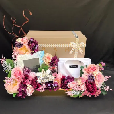 A luxurious wedding trousseau platter for the groom, featuring a designer shirt, accessories, and other gifts, all surrounded by a lavish floral arrangement. This is how you make a statement.