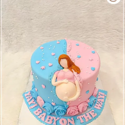 A fun "Yay! Baby on the way!" cake for a gender reveal party. The half-pink, half-blue design with a fondant pregnant belly is a creative way to build excitement.