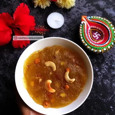 A bowl of our rich and decadent Kesari Bath, a traditional South Indian sweet. Made with roasted semolina, pure ghee, and fragrant saffron, then garnished with cashews, it's a festive dessert for any celebration.