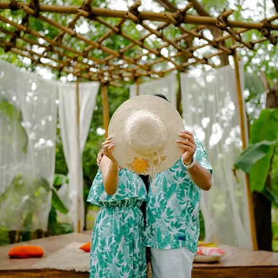 A playful and cute moment where the couple hides behind a sun hat. This shot, taken at our Bali-themed set in Mumbai, is fun, candid, and perfect for a save-the-date.