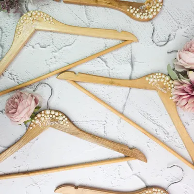 The perfect shot starts with the perfect hanger. We create these beautiful wooden hangers, personalized with names and embellished with pearls, for your wedding dress and bridesmaid gowns.
