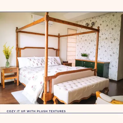A classic four-poster bed brings a touch of timeless elegance to this bedroom. Paired with a delicate botanical wallpaper and a plush bench, this space is designed to be a cozy and luxurious retreat.