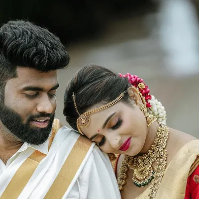 A tender moment between the newly married couple, dressed in traditional South Indian wedding attire. This candid portrait captures the quiet connection and happiness right after the main ceremony.