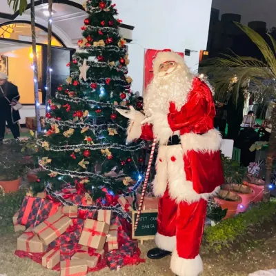 Our Santa Claus character stands beside a beautifully decorated Christmas tree, ready to bring holiday cheer to your party or event.