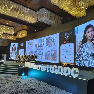 A shot of our director on the big screen during the panel discussion at the Marriott Global Design & Development Confluence 2024.