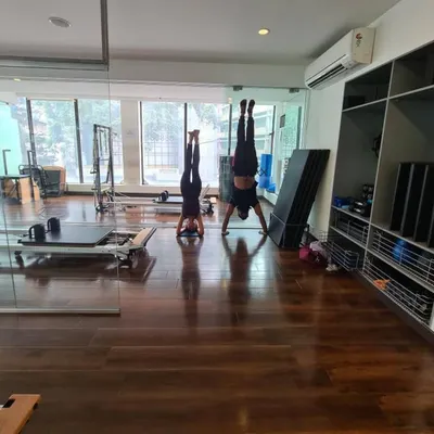 Forget the past and look to the future. A partner handstand, showcasing balance, trust, and a shared commitment to fitness.