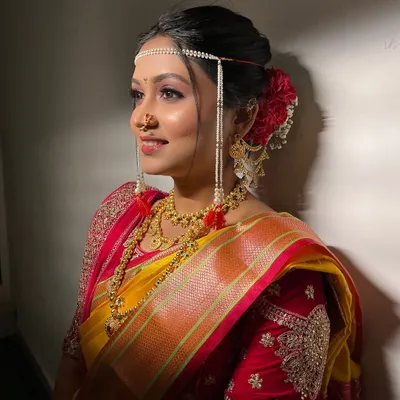 A side profile of my minimalist bride, showing the elegant Khopa hairstyle with a red rose and the delicate mundavalya.