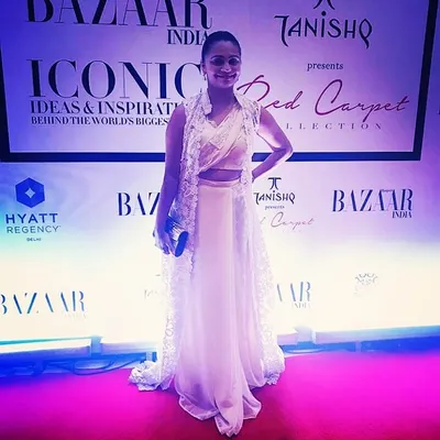 It was a pleasure to design this outfit for a client attending a Harper's Bazaar red carpet event. This elegant white ensemble features a crop top, flowing skirt, and a long, sheer lace jacket.