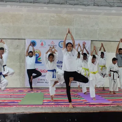 Students holding the Vrikshasana (tree pose) during a yoga session. This pose is fantastic for improving balance and focus, which are critical skills in martial arts.