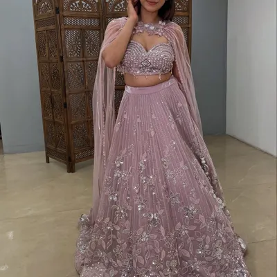 A stunning mauve Indo-western lehenga with a dramatic attached cape. This pre-loved designer piece is perfect for making a fashion-forward statement.