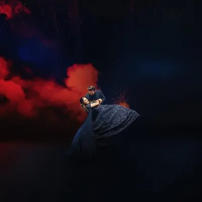 A dance under a sky of red smoke and fireworks. This is a perfect example of a highly stylized and dramatic pre-wedding shot, creating a powerful and artistic visual that is full of passion.