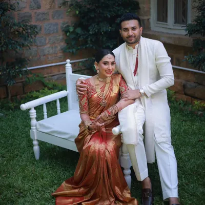 A beautiful portrait of the bride and groom. Her traditional muhurtham makeup features a warm, golden glow and a classic red lip, perfectly harmonizing with her red and gold silk saree.