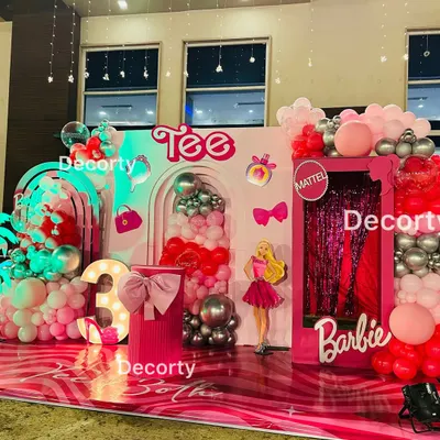 "Come on Barbie, let's go party!" This glamorous Barbie-themed stage is a dream in shades of pink, featuring a life-sized Barbie box photo booth, neon signs, and a light-up number three.