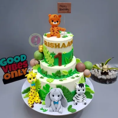 A special jungle-themed cake for little Rishaan's first birthday, complete with a rotating top tier and adorable fondant animals.