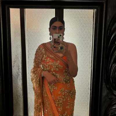 A mirror selfie in a stunning orange Sabyasachi saree. This is my go-to for palace weddings, combining traditional elegance with a vibrant color.