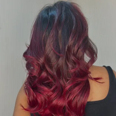 Fire in her hair. This stunning bright red ombre is styled with bouncy curls to show off the intense, vibrant color.