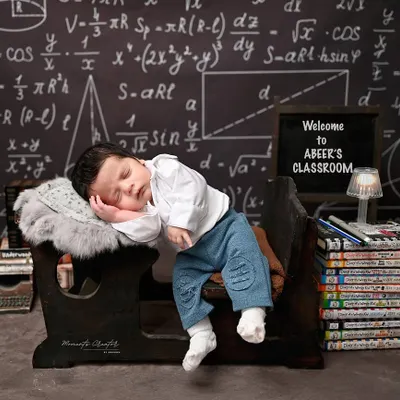 A tiny professor, fast asleep on the job. This creative and adorable one-month-old photoshoot captures the quiet, sleepy nature of the newborn phase in a fun and unique way.