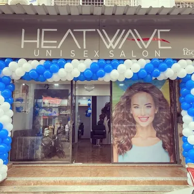 A blue and white spiral balloon arch for the inauguration of Heatwave Unisex Salon, creating a clean and professional look.