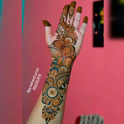 A beautiful Arabic mehndi design that flows elegantly from the fingers up the arm, featuring bold circular and floral patterns.