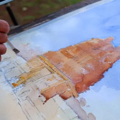 This is a work-in-progress shot of my Hampi landscape watercolor. You can see the initial pencil sketch and the first layers of color being applied to capture the texture of the ancient stone structures.