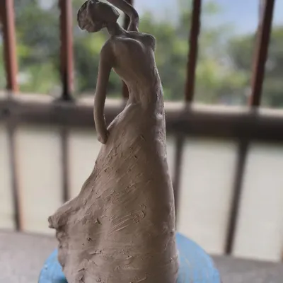 A clay sculpture of a dancing woman, captured before firing. I wanted to express a sense of graceful movement in her pose.