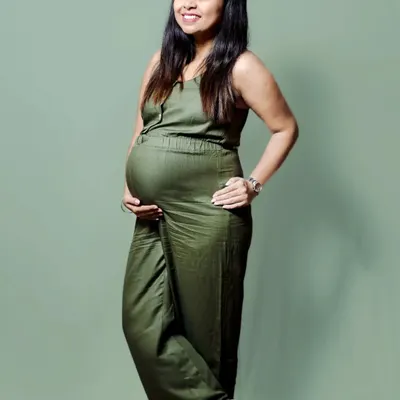 You don't need a gown to have a beautiful maternity photo. This mom to be looks amazing and comfortable in a casual jumpsuit during a relaxed session at home.
