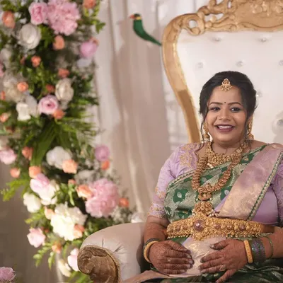 Our client Pavithra Gowda, radiant at her baby shower. The lavender and green dual-tone silk saree drapes her in serenity and renewal, mirroring the beautiful journey of motherhood.
