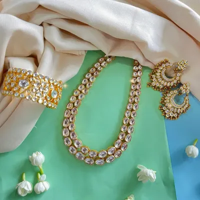 Add a touch of royalty to your collection with our stunning Kundan jewellery set. The necklace, earrings, and wide cuff bracelet are perfect for any grand occasion.
