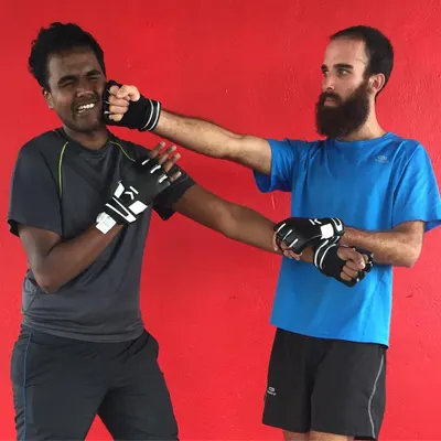 Students engage in a sparring drill wearing protective gloves. This practice helps build timing, reflexes, and the confidence to use Wing Chun techniques under pressure.