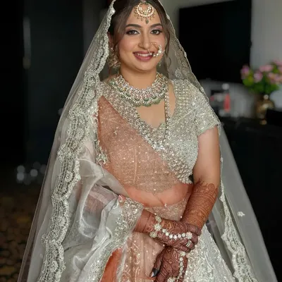 The final look for my beautiful bride Dhruvi. Her makeup features a soft, dewy base and neutral tones to complement her stunning silver and peach lehenga, ensuring she looked effortlessly radiant.