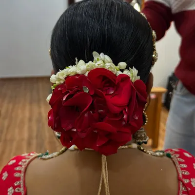 A classic bridal bun made with real red rose petals and a touch of gajra. This is a timeless hairstyle that always looks elegant.