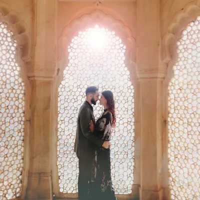 A classic pre-wedding portrait set against a beautifully sunlit palace window. This is the essence of our royal shoots, combining architectural beauty with romantic poses to create timeless images.