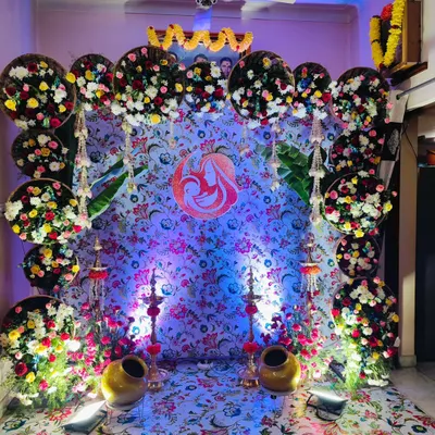 A traditional baby shower decoration set up inside a client's home. We used a floral print backdrop framed with circular arrangements of fresh, colorful flowers to create a warm and blessed space for the mother-to-be.
