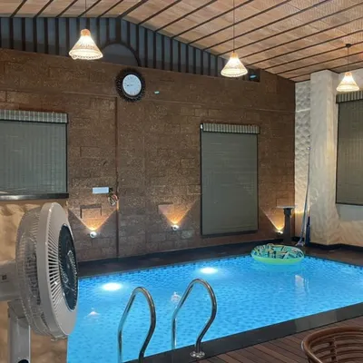 An intimate indoor pool area where we used a mix of materials like rustic finish stone and wood to create a warm, enclosed space. The pendant and wall lighting are strategically placed to enhance the mood for evening relaxation.