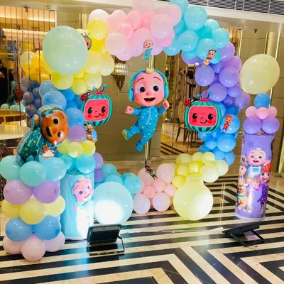 A cheerful Cocomelon themed birthday arch. This setup features JJ and watermelon character balloons amidst a rainbow of pastel balloons, perfect for a toddler's party.