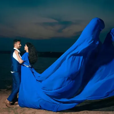 Our royal blue flying dress creates an unforgettable image against the twilight sky. The massive trail appears to take flight, perfect for a dramatic couple's portrait by the water.