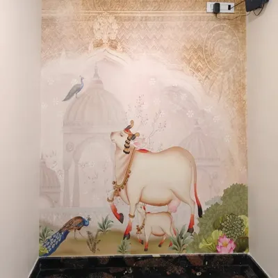 A beautiful Pichwai-style mural featuring a sacred cow and calf against a backdrop of traditional Indian architecture, bringing a sense of peace to this space.