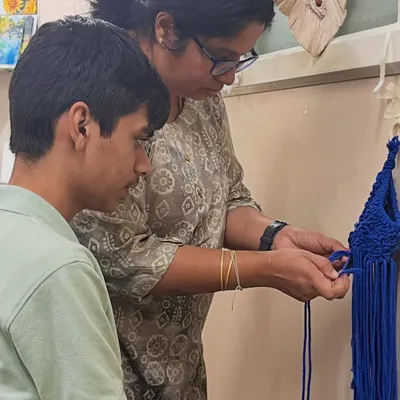 I'm teaching a student the basic knots of macrame. This hands-on guidance helps build confidence and ensures a beautiful result.