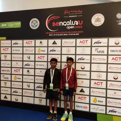 Our top junior players, Sanjay and Ishaan, in front of the official sponsor wall at the Bengaluru Open 2022. We provide our students with exclusive access to professional tournament environments.