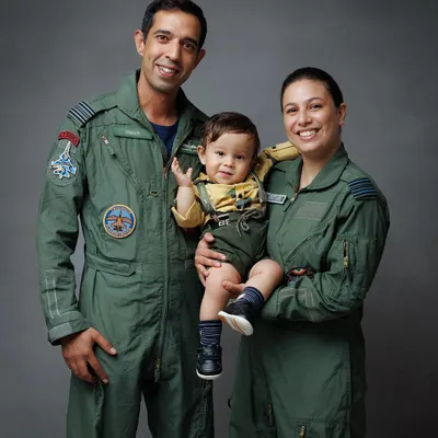 A proud family portrait of Airforce pilots with their little one. This image captures their unity, love, and the unique story they share.