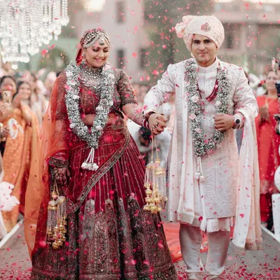 A classic wedding portrait of Rhea and Abhimanyu, walking down the aisle, showered in petals, the epitome of a happy couple.