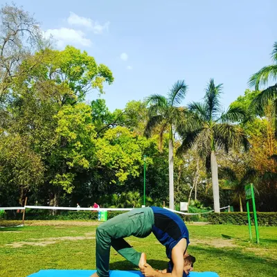 Practicing a variation of Chakrasana (Wheel Pose) in a beautiful green park. Taking care of your body is the most important thing, and nature provides the perfect backdrop.
