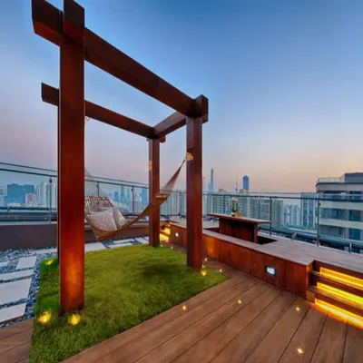 We specialize in turning high-rise terraces into luxurious retreats. This project features a custom wooden deck, a relaxing hammock, and soft lighting, all set against a stunning city backdrop, proving that green living can be exceptionally stylish.