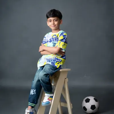 A cool and casual portrait of a 7-year-old boy, showing off his sporty side with a soccer ball.
