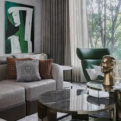 This family lounge in our Chennai project was designed as a retreat. A large window frames the view of the trees outside, blurring the boundary between inside and out. The sculptural green leather chair provides a perfect spot for stillness and reading.