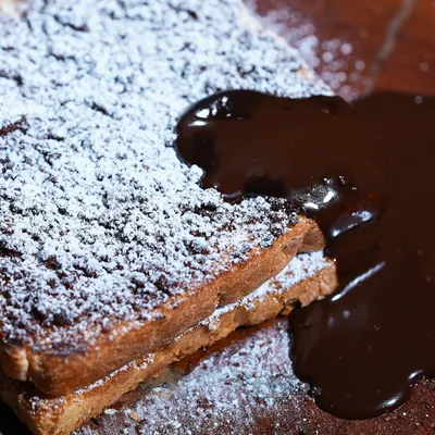 A close-up of my vegan Chocolate French Toast, dusted with powdered sugar and ready to be devoured. It's the perfect balance of crispy, soft, and wonderfully chocolatey.
